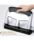 Hand using EZ Squeeze Heavy Duty 3 Hole Punch With 40 Sheet Capacity, All Metal Build, Fifty Percent Less Force, Anti Slip Rubber Base