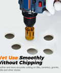 Front view of blue cordless drill with 1-1/4in gold diamond hole saw drilling ceramic tile.