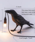 Cool Crow Table Lamp With Resin Bird Design, black finish, shows measurements for body and cord; LED bulb hanging from beak.