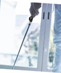 Person using Golf Grip Trainer Pro Grade Swing Training Device Alignment Aid with putter indoors near balcony.
