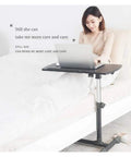 Slick Height Adjustable Laptop Table With Smooth Rolling Locking Casters Premium Couch Side Stand Heavy Duty Wood Finish Foldable Computer Cart For Lazy Day Lounging with user working in bed.