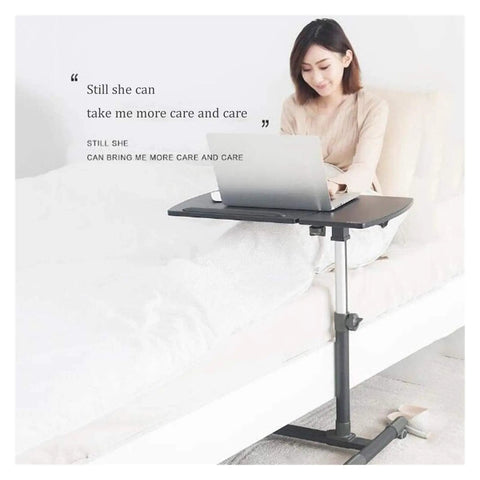 Slick Height Adjustable Laptop Table With Smooth Rolling Locking Casters Premium Couch Side Stand Heavy Duty Wood Finish Foldable Computer Cart For Lazy Day Lounging with user working in bed.