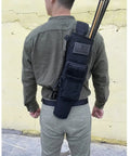 Person wearing the Lightweight Back Archery Quiver With Dual Use Foldable Hip Bag, black, holding arrows.
