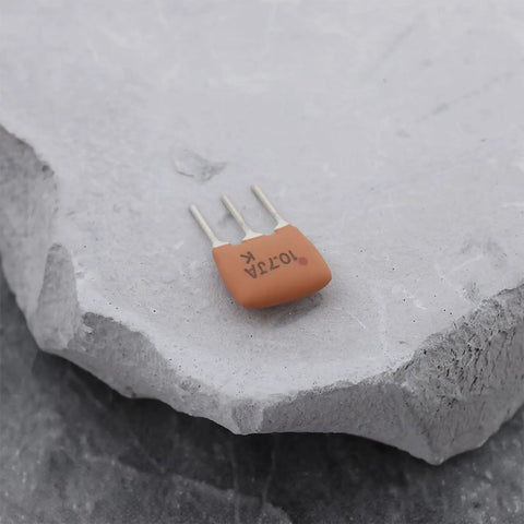 Close-up of 20 Pack Ten Point Seven Megahertz Ceramic Filter Crystal Oscillators for RF and IF Circuits on stone surface