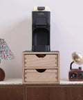 Double Tier Wooden Coffee Maker Stand With Pull Out Storage Drawer For K Cups And Capsules Countertop Brew Organizer Rack on a table next to a lamp.