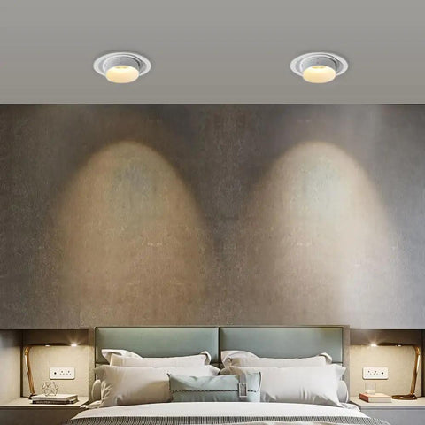 Two UWYTGF 10 Pack 4.5 Inch Gimbal Led Recessed Lights illuminating a stylish bedroom wall with adjustable focus.