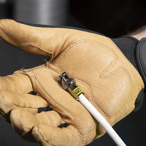 Gloved hand holding Universal BNC Compression Coax Connector For RG6 And RG6 Quad Shield Cables Male 10 Pack in installation setting