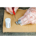 Hands with gloves mixing components of Solid Alloy Wheel Repair Kit For Black Rims DIY liquid aluminum compound.