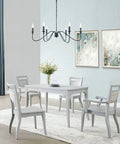 Six Light Rustic Industrial Iron Chandelier With Matte Black Finish hanging in a dining room, above a white table set.
