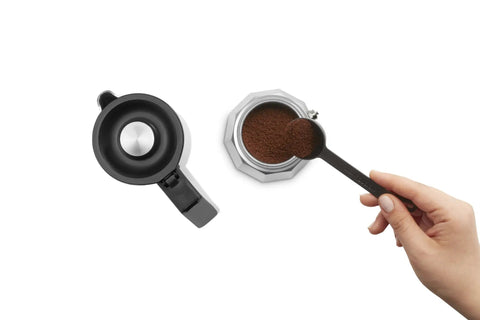 Hand adding coffee to Dope All In One Turkish Coffee And Moka Pot With Milk Frother, Dual Brew Machine, 5 cup capacity