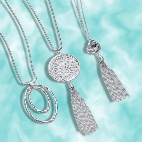 Silver version of six piece long pendant necklace set for women with tassel, knot, disk, and circle designs in gold tone