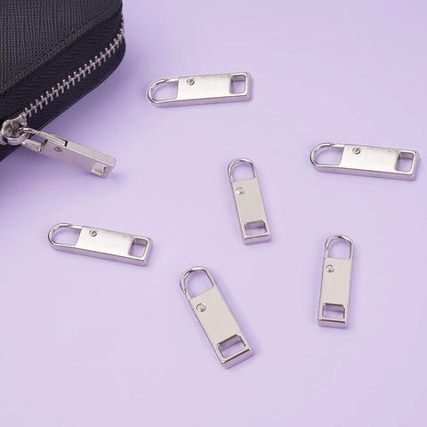 Zipper Pull Replacement Set Six Pack Metal Zipper Handles For Luggage Backpacks Suitcases Jackets Purses And Handbags Easy Clip On Repair Tool No Tools Needed For Everyday Use shown with silver zipper pulls.