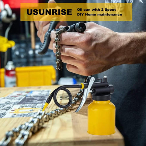 Dual spout metal pump oiler in use for bike chain lubrication on workbench.