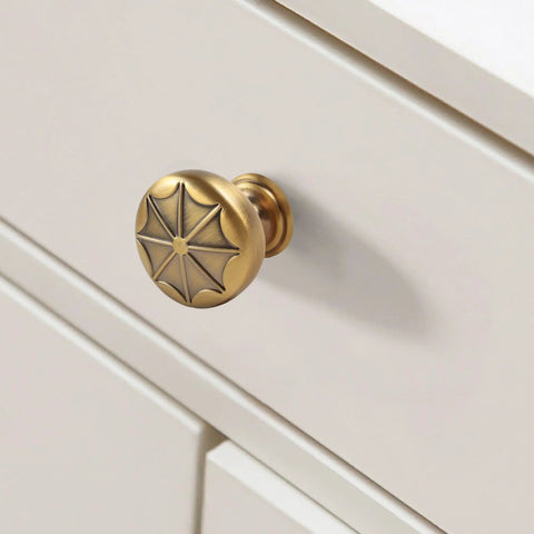 Durable Zinc Alloy Vintage Cabinet Knobs Five Pack - Antique Brass Drawer Pulls Art Deco Star Detail 1 1/8 Inch on white drawer.