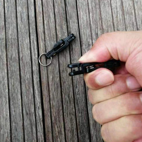 Keproving fishing line release clips, black plastic with metal O-rings, two pieces held in hand
