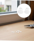 Anchor-Shape LED Strip Clips White Plastic Mounting Brackets on desk beside scissors for easy installation