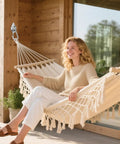 Woman relaxing on a hammock hung with Heavy Duty Hammock Hanging Kit With Stainless Steel Pad Eye Hooks And Mounting Screws.