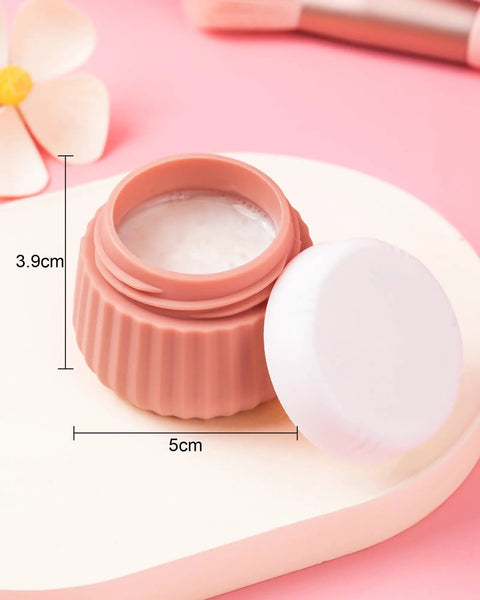 Open silicone jar from TSA Approved Travel Containers Four Pack With Leak Proof Silicone Jars And Rose Gold Transparent Cosmetic Bag For Toiletries 1 Ounce Carry On Essentials Perfect For Weekend Getaways And Business Trips On The Go showing white contents, pink background.