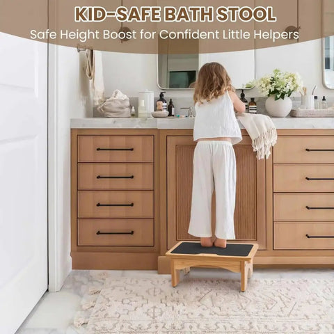 Child using wooden stool at bathroom vanity with storage cabinets underneath