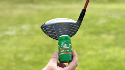 Hand holding anti-slice golf rub near a golf club head, fix your slice instantly hit straighter and longer drives reduce spin.