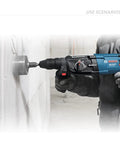 Worker using Beefed Up 15 Piece Concrete Hole Saw Kit With SDS Plus Shank on wall, showing 40mm hole size application.