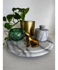11.75 Inch Marble Lazy Susan Turntable With Vintage Gray Stone Finish, holding decor items and plant, on a table.