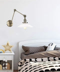 Wall Sconce Lights Indoor Bedroom Hallway Swing Arm Lamps with Switch,Adjustable Metal,Clear Glass Shade,Hardwired Industrial Lamp for,and Living Room, mounted over a bed.