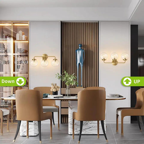 Three Light Vanity Wall Sconce Over Mirror In Matte Gold Finish With Transparent Glass Ball Shade in modern dining area.