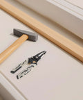Pretyzoom 7-In-1 Cable Stripper And Crimper For Electricians with hammer and wooden plank on table.