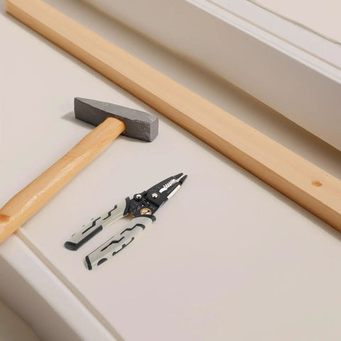 Pretyzoom 7-In-1 Cable Stripper And Crimper For Electricians with hammer and wooden plank on table.