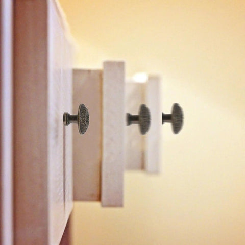 Side view of vintage zinc alloy drawer pull ring and cabinet handle set on wooden drawer with retro vibe.