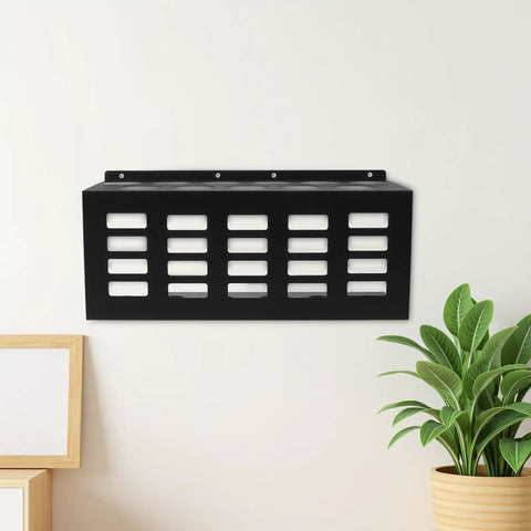 Badass Wall Mounted Caulk Tube Organizer Rack With 11 Hella Durable Slots showing black frame on wall with plant beside it.
