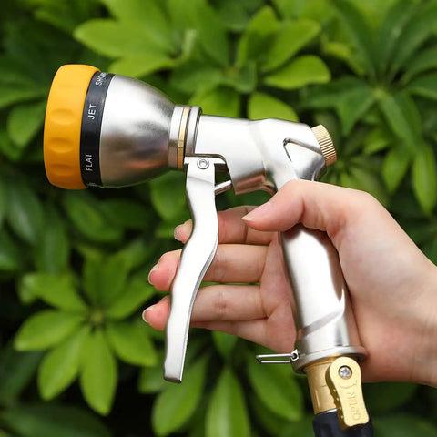 Person holding Heavy Duty Metal Hose Nozzle Sprayer With 7 Spray Patterns For High Pressure Watering And Car Wash against greenery