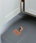 20 Piece Plastic And Iron Drawer Stopper Set placed near cabinet door, showing square and L shape pieces for dressers and cabinets repair.