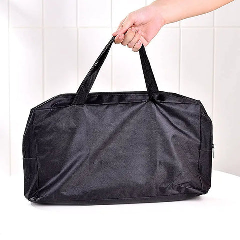 Carrying bag for Ultra Lightweight Portable Folding Camping Grill With Handy BBQ Tool Set, shown with hand holding straps.