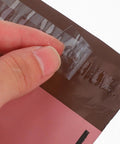Close-up of adhesive seal on Pink 15x27cm Self Sealing Poly Mailer Bags Pack Of 100 Tear-Resistant Shipping Mailers For Small Business