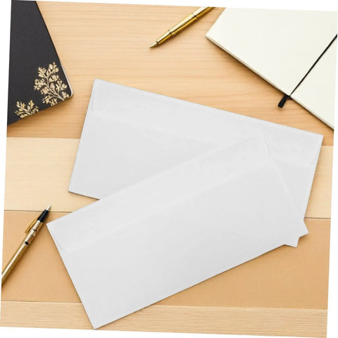 White Pro-Grade Self-Sealing Security Mailing Envelopes 115mm X 225mm on a wooden desk with pens and notebooks.