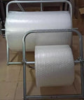 Heavy Duty Bubble Wrap Roll Dispenser Tabletop Packing Station Manual Foam Cushion Holder For Shipping And Moving Supplies Galvanized Steel Stand with two rolls of bubble wrap.