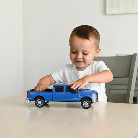 Child playing with Realistic Ford Gooseneck Truck Toy And Trailer Hitch 1 To 20 Scale Farm Toy Set For Kids And Collectors