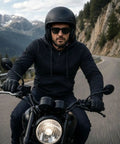 Biker wearing Streetguard Riding Hoodie With Aramid Armor And CE Shoulder Elbow Protection, riding motorcycle on mountain road.