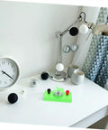 Mini Solar Powered Generator Motor For DIY Science Projects And STEM Kits on a desk with lamp and clock, quiet operation.