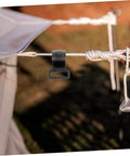 Installed 10 Pack Plastic Tent Pole Hooks For Glamping And Camping Gear Hanger on a rope, close-up in outdoor setting.
