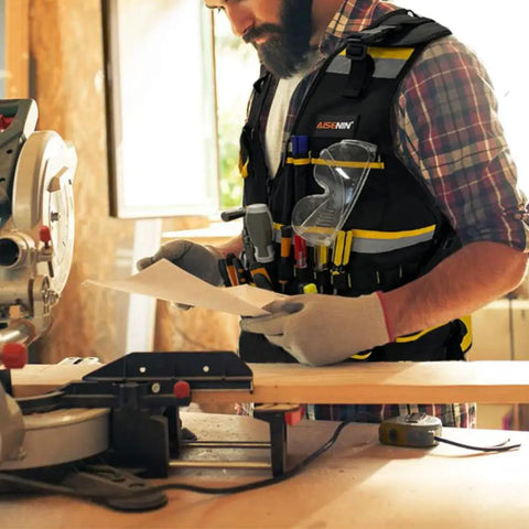 Electrician wearing Reflective Safety Tool Vest With Multiple Pockets And Zipper Heavy Duty Work Vest For Carpenters, black and yellow.