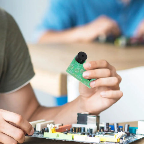 Person holding Dope Dual 555 Timer Circuit Kit for Electronics Training and DIY Projects, with NE555 multivibrator visible