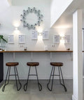 Modern kitchen interior with stools, wall art, and shelving supported by heavy duty 20 inch shelf brackets pack of 2, stainless steel.