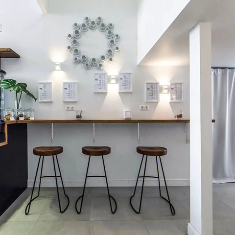 Modern kitchen interior with stools, wall art, and shelving supported by heavy duty 20 inch shelf brackets pack of 2, stainless steel.