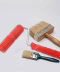 Red Grain Pattern Paint Roller For Wall Texturing With Ergonomic Plastic Handle alongside two paint brushes on a white surface.