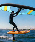 Person using Inflatable Windsurf Wing 5m2 for kitesurfing and wing foil, handheld above water, bright day, polyester build