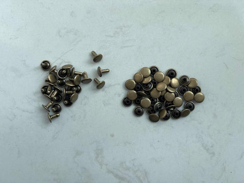 Top-down view of copper rivets for grounding barefoot shoes; small size with black washers.