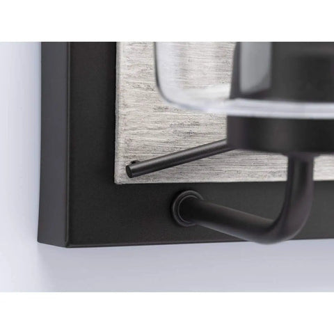 Close-up of Three-Light Coastal Bath Vanity Light with faux woodgrain backplate and graphite black finish detail.